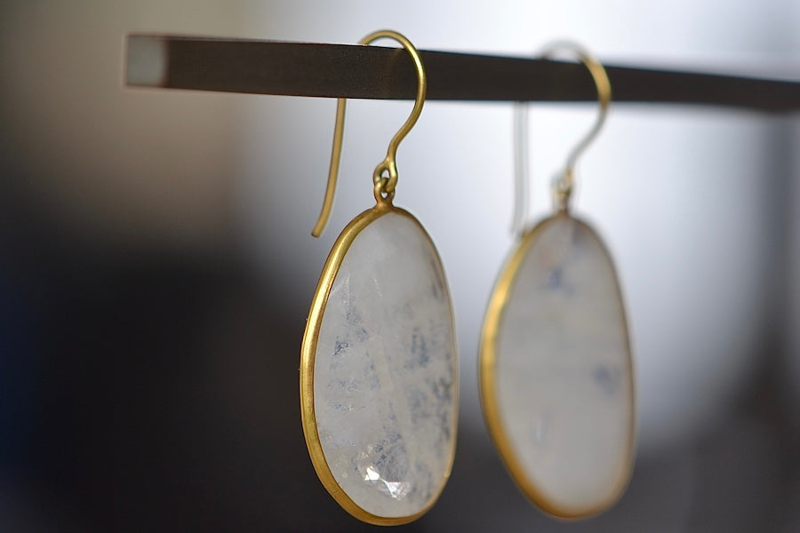 Side view of Large Drop Rainbow Moonstone Earrings by Pippa Small are translucent, lightly faceted and bezel set stones on ear wire in 18k yellow gold.