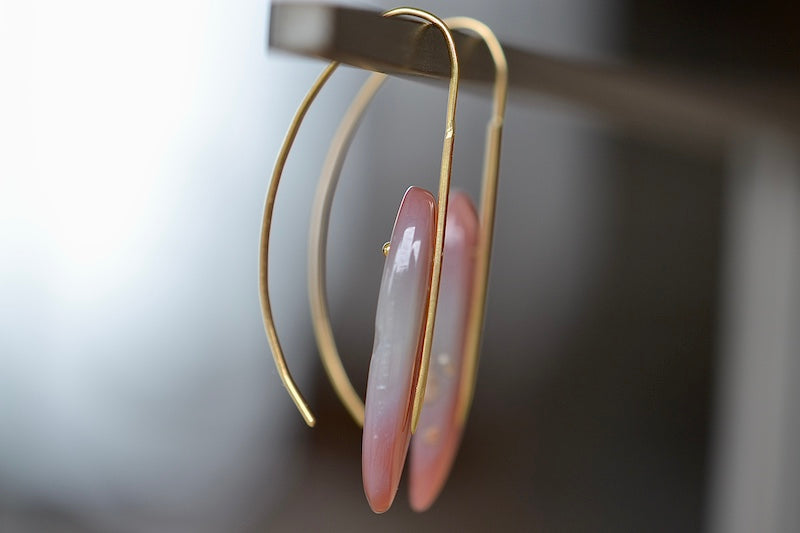 Side view of feather earrings in Red Agate by Rachel Atherley.