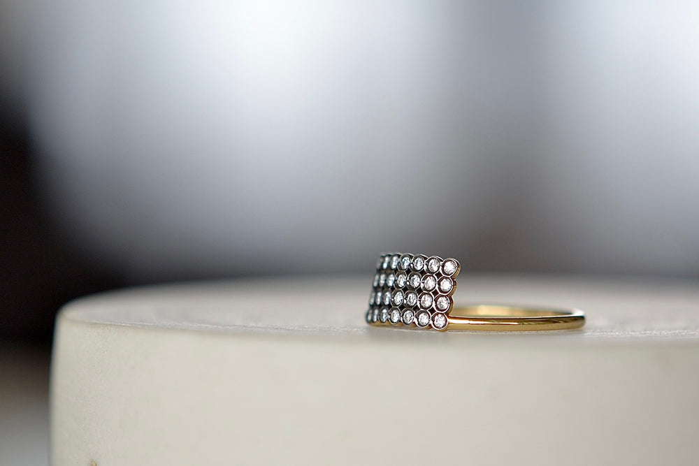 Turning the Charnières Rectangular Ring up. Designed by Yannis Sergakis is a rectangular formation of twenty-eight bezel set and rhodium plated round cut diamonds on a gold band in 18k gold. 