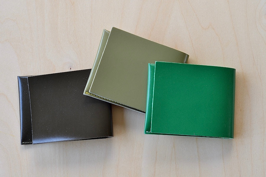 Simple Flap wallets in dark brown, olive and Kelly green from architect Alice Park shown folded.