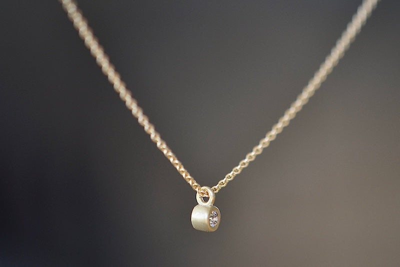 Dainty Necklace with Diamond by Carla Caruso is a forever necklace of a simple and sparkly white diamond bezel set in 14k yellow gold and satin finish on a chain. Handmade in Massachusetts.