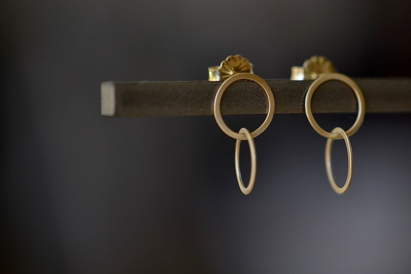 Double Circle Stud Earrings by Carla Caruso are Two thin and flat interlocked circles in 14k yellow gold and satin finish with post closure. Elegant Everyday earrings.