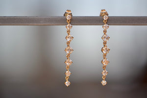 Éclat Seven Drop Earrings by Lizzie Mandler are comprised of seven (7) compass set white diamonds each with a chain in between on post closure in 18k gold.