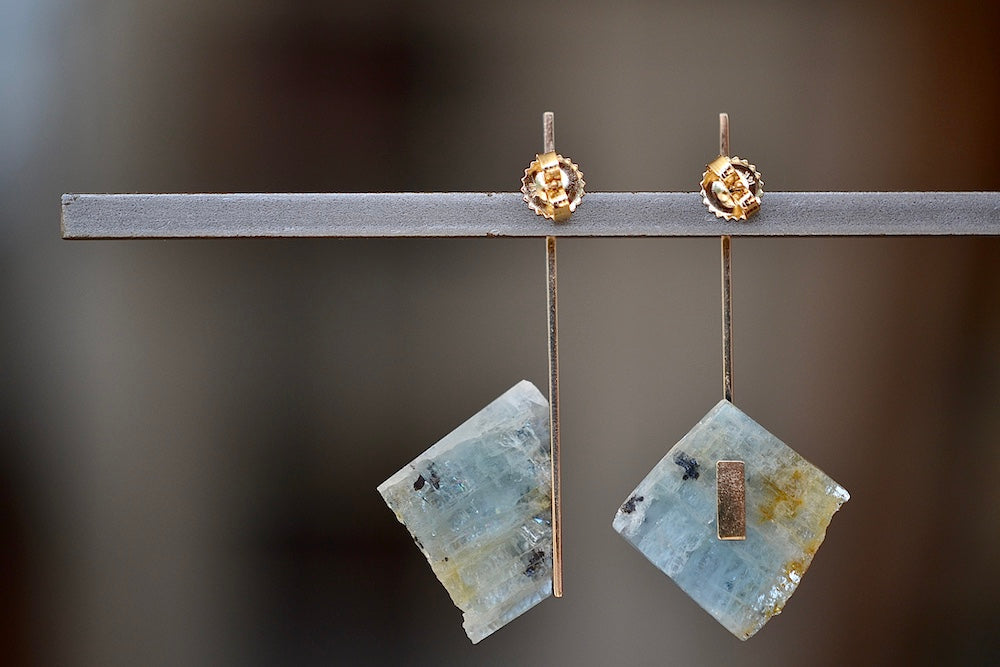 One of a kind asymmetrical aquamarine stone earrings stones with natural inclusions attached to Kathleen Whitaker's signature elongated gold plate studs with post closure. Stone Collection.