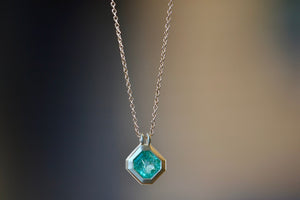 Duo Bale Offset Emerald Necklace by Elizabeth Street Jewelry is a  bezel set, translucent and offset square Columbian emerald with twin bales and on a 14k yellow gold chain. Perfect for layering or to wear as a solo piece. 