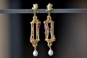 Polly Wales Jade Terrace Pagoda Earrings 18K yellow recycled gold pagoda forms hanging from a bird stud encrusted with a pearl pink and orange sapphire sapphires. Cast not set.