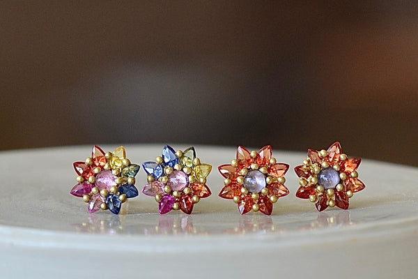 Rainbow and Orange Daisy studs earrings by Polly Wales. A floral cluster made out of a half sphere in gold with a cabochon and encrusted inverted brilliant sapphires. We have one pair in rainbow. Recycled gold. Cast in Place. Cast not set. Handmade in Los Angeles.