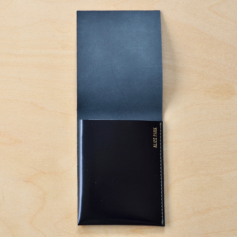 Inside of Dark Black Alice Park simple flap wallet with white stitching.