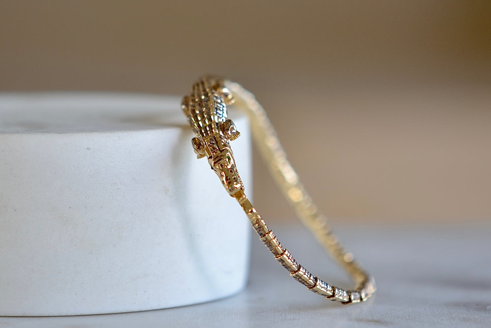 
            
                Load image into Gallery viewer, Alligator Wrap Thin Bracelet by Bibi Van Der Velden is a tennis style bracelet in 18k yellow gold with tsavorite eyes.
            
        