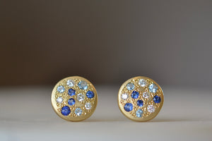 Tidal Pool studs by Adel Chefridi are classic round studs with mixed blue sapphires, aquamarines and diamonds in 18k gold on classic post closure.