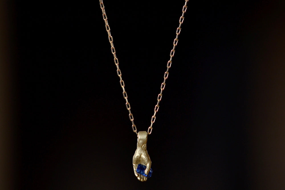 Hand pendant with dark blue sapphire by Fraiser Hamilton.