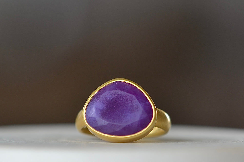 Sugalite Greek ring by Pippa Small Jewelry is a n Organically shaped, hand cut, and faceted sugalite stone set in 18k yellow gold. Size 6.5 in stock.