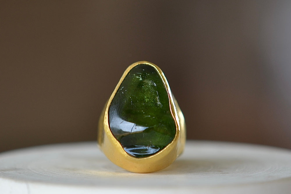 Green Tourmaline Tibetan ring by Pippa Small Jewellery is based on a ring that Pippa bought in Tibet many years ago this design features a hand picked and smooth tumbled green tourmaline that is encased in 22k gold.