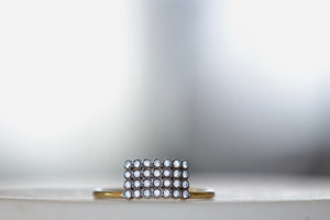 Charnières Rectangular Ring designed by Yannis Sergakis is a rectangular formation of twenty-eight bezel set and rhodium plated round cut diamonds on a gold band in 18k gold. 