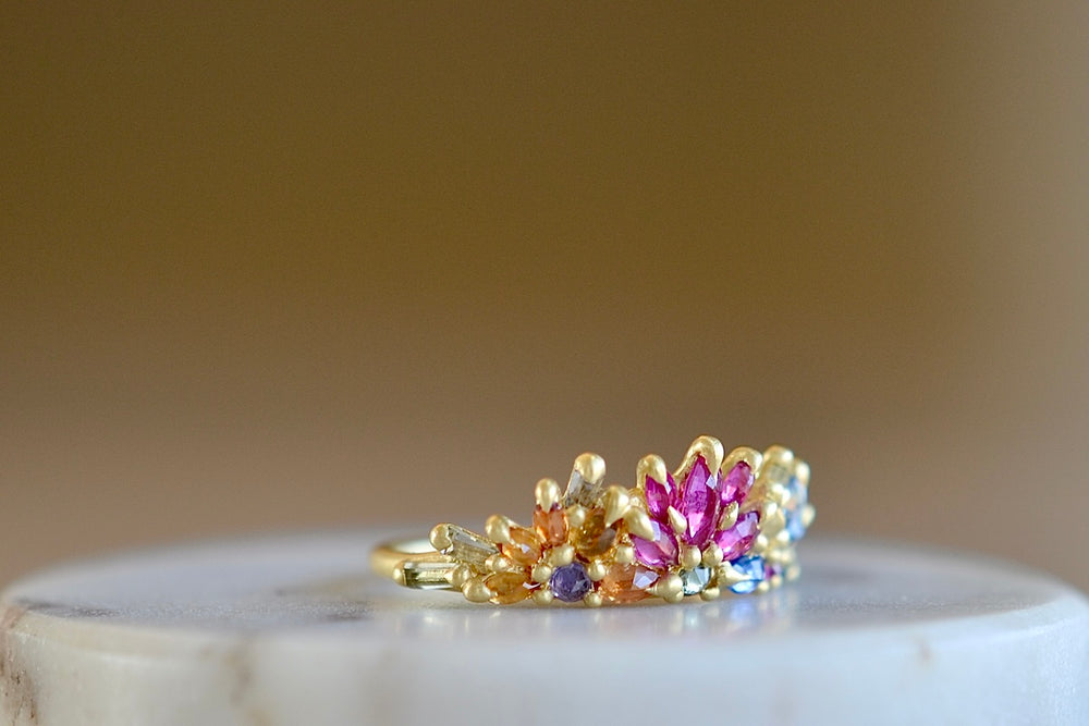 Side view of Rainbow Daisy Garland Petal Ring by Polly Wales. 