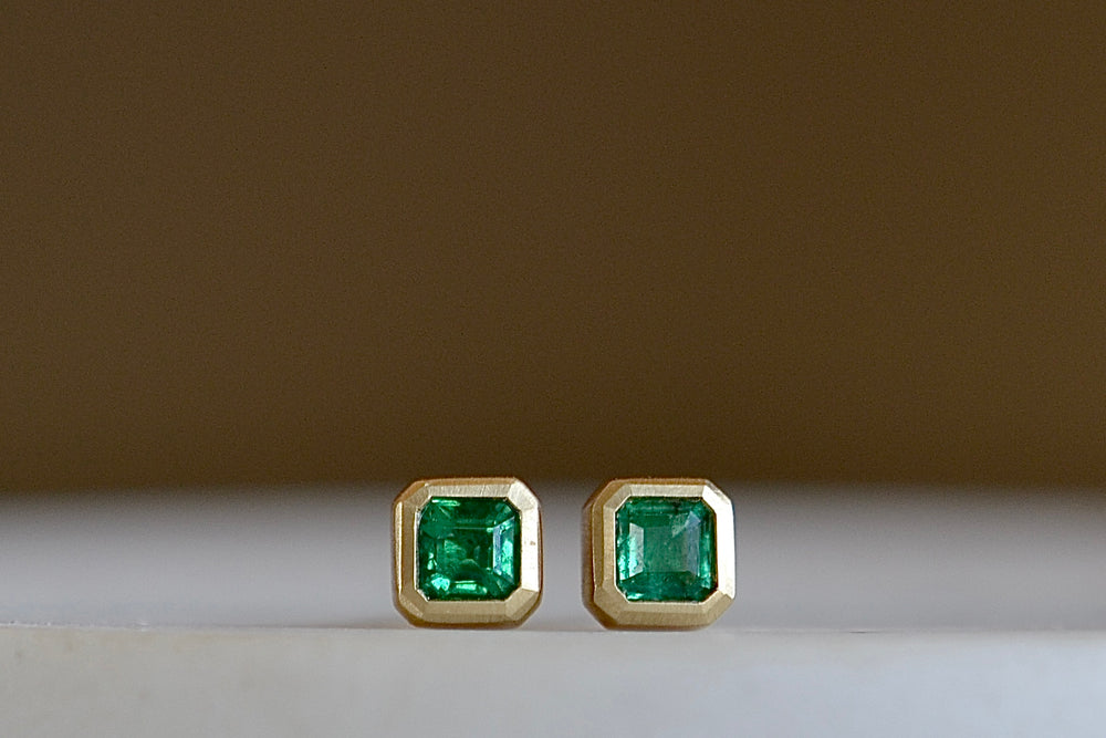 
            
                Load image into Gallery viewer, Petite Emerald Stud Earrings by Elizabeth Street Jewelry are square and bezel set Columbian emeralds on post closure.
            
        