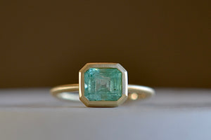 
            
                Load image into Gallery viewer, Simple emerald band ring by Elizabeth Street 23A is a 1.35 CT Columbian emerald in a 14k bezel and band.
            
        