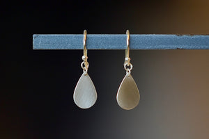 Pair of Teardrop Earrings by Carla Caruso. A single gold and flat teardrop hangs from an ear wire in 14k satin gold, allowing for lots of movement. Handmade in Massachusetts.