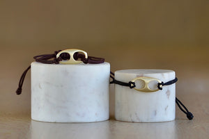 Marina Bracelet by Lisa Ziff in brown and black. A simple, everyday and unisex bracelet made out of a soft edged single link in 10k yellow gold on an adjustable nylon cord in black or brown.&nbsp; It is large enough for men and easily adjusted down for women. Handmade in Los Angeles.
