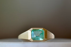 Emerald Signet ring by Elizabeth Street Jewelry is a one of a kind lightly faceted Colombian emerald on a tapered band with squared edges in 14k satin finish yellow gold.