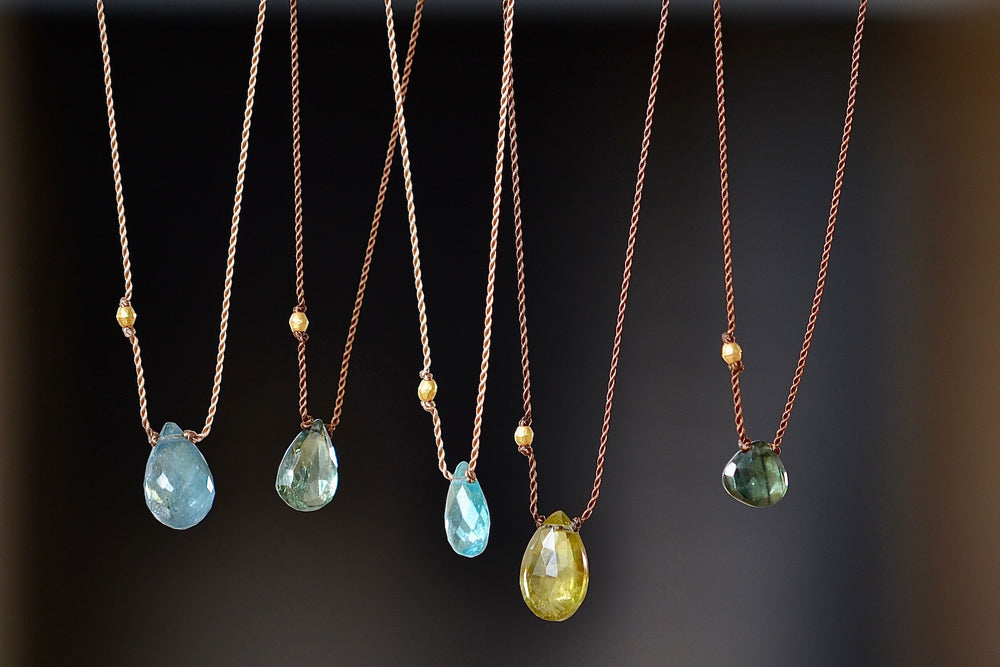 Four Tourmaline and one Apatite necklaces with 18k bead on poly nylon cord by Margaret Solow.