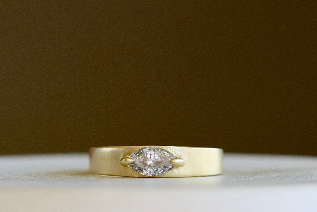 Slim Cigar Band with Diamond by Elizabeth Street Jewelry is a band with slight taper and a marquise cut salt and pepper diamond in a two prong eagle claw bezel setting, using 14k gold. Handmade in Los Angeles. Size 6.5 in stock.