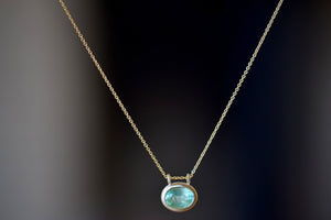 Duo Bale Oval Emerald Necklace by Elizabeth Street Jewelry is a bezel set oval Columbian emerald with twin bale on a 14k chain.