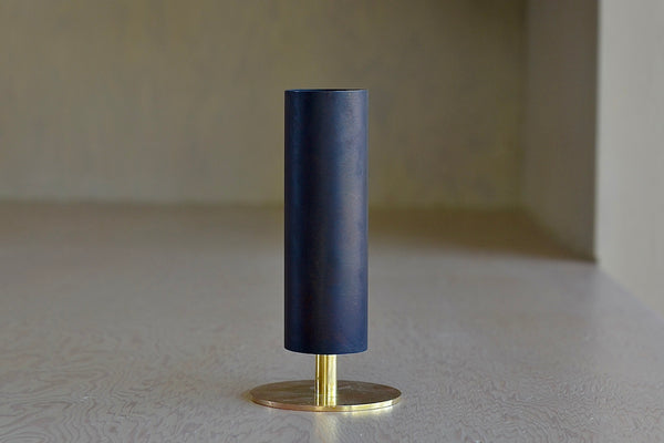 The Aubock Vase on Pedestal in small 7247-2 is a tall and thin rimmed patina brass tube vase with polished base in small. designed by Carl Auböck.