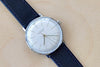 Max Bill 34mm Hand wound Watch in White Dial Without Numbers designed for Junghans in 1961 and is virtually unchanged. 34mm hand wound watch with black face and numbers with hand winding movement J805.1 (ETA 2801-2) and a sapphire crystal,  42 Hour Power Reserve in 316L stainless steel case available at OK. 27/3700.02
