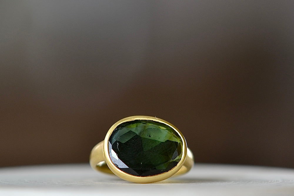 Green Tourmaline Greek ring by Pippa Small is an organically shaped, deep green, faceted and translucent green tourmaline set in 18k yellow gold. Size 6.5 in stock.