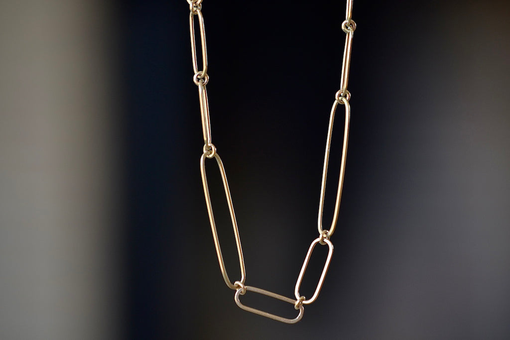 Short 14k gold paperclip chain with two short, one long flat clips in 15 inches by Kaylin Hertel.