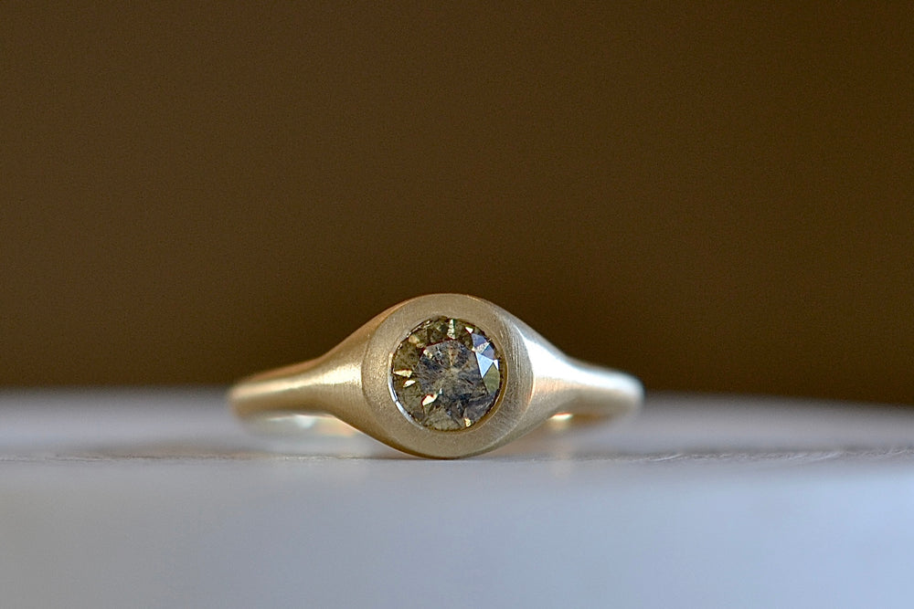 Champagne Solitaire petite signet by Elizabeth Street in a matte gold band.