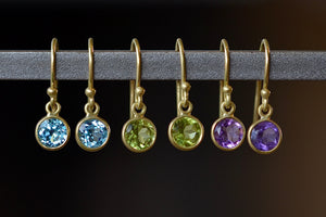 
            
                Load image into Gallery viewer, Tiny moon earrings by Tej Kothari are lightly faceted and translucent bezel set round and inverted stones on a gold ear wire hook in blue topaz, peridot or amethyst.
            
        
