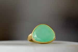 The Chrysoprase Greek Ring by Pippa Small Jewellery is an organically shaped, and hand cut, bright green, faceted and translucent chrysoprase set in 18k yellow gold. Size 6.5 in stock.