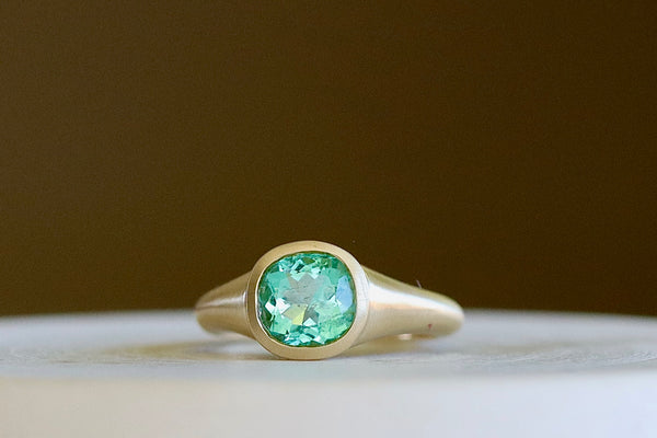 Colombian Signet by Elizabeth Street in size 6.5 is a one of a kind signet comprised of a lightly faceted Colombian emerald on a tapered band in 14k satin finish yellow gold. Handmade in Los Angeles.