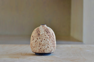 Other side of striped cream to brown bottle volcanic vase by Heather Rosenman.