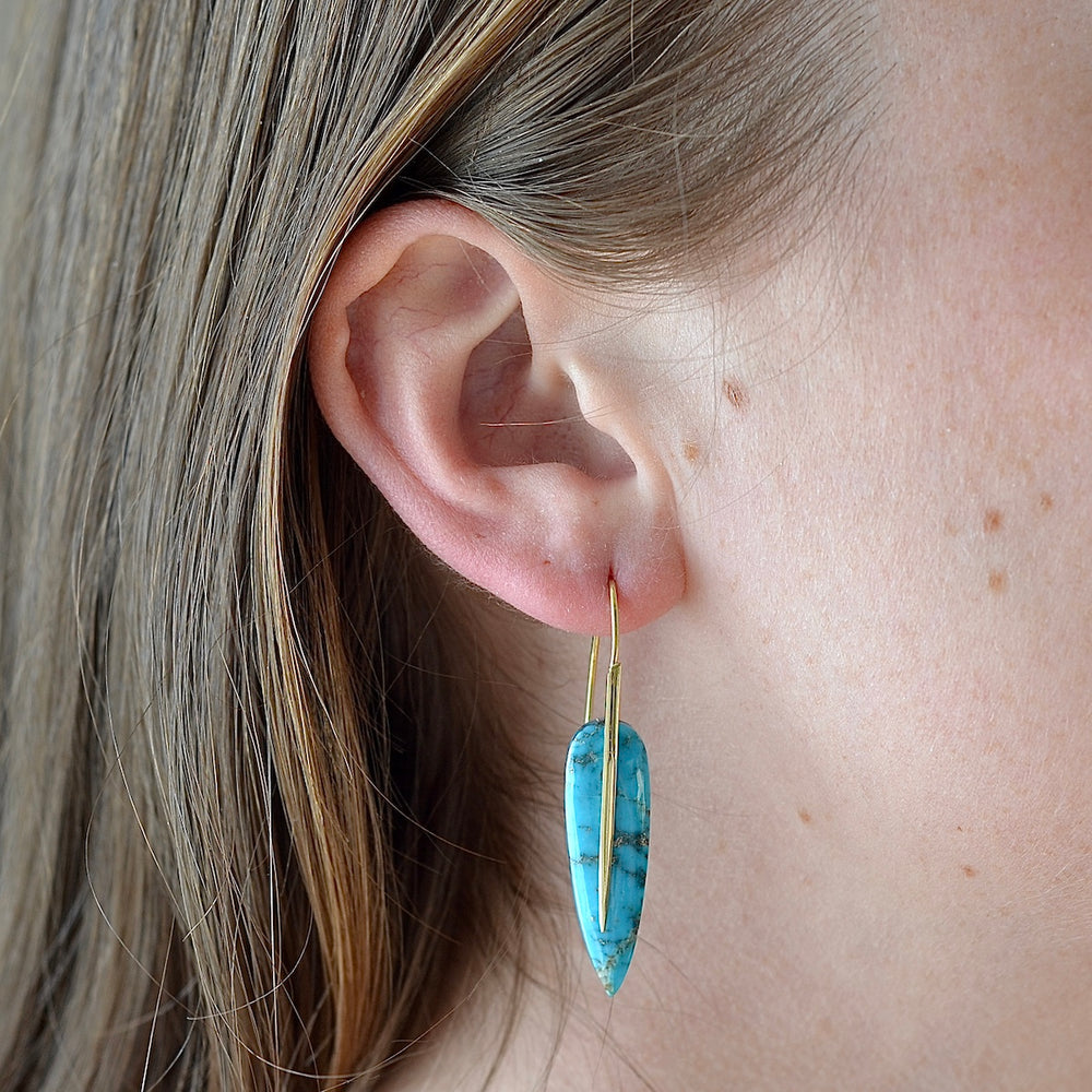 Wearing the Feather Earrings in Turquoise by Rachel Atherley.