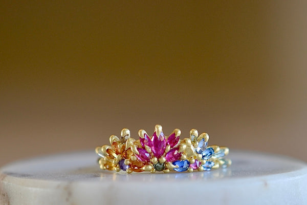 Rainbow Daisy Garland Ring y Polly Wales is a ring of Encrusted rainbow sapphires on a petal crown ring in 18k recycled yellow gold. Cast in Place. Cast not set. Handcrafted in Los Angeles. 
