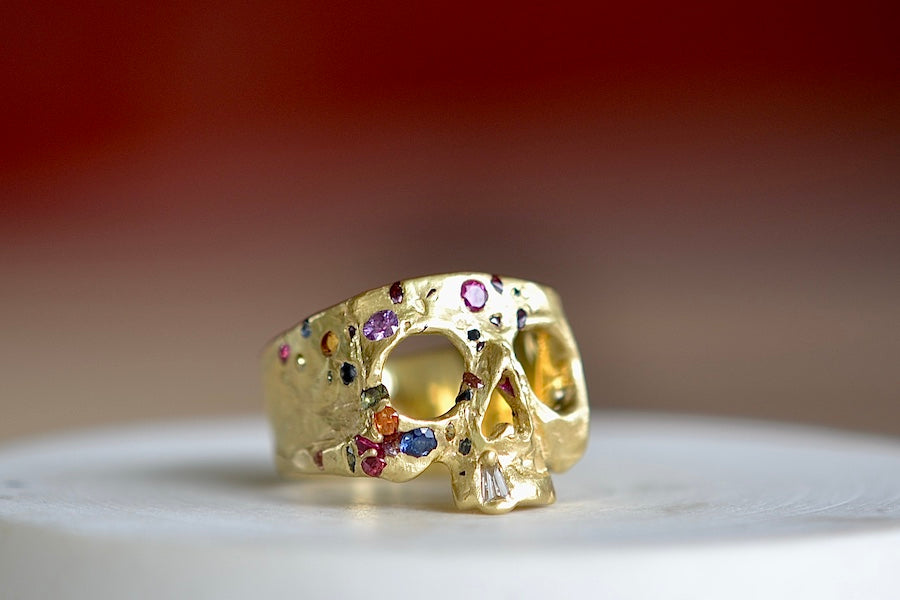 Side view of the Polly Wales Rainbow Confetti skull ring with one diamond tooth.
