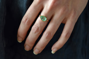 Wearing the simple pear emerald ring by Elizabeth street is a 14K and 1.74CT East West set pear cut Columbian Emerald Basic Ring.
