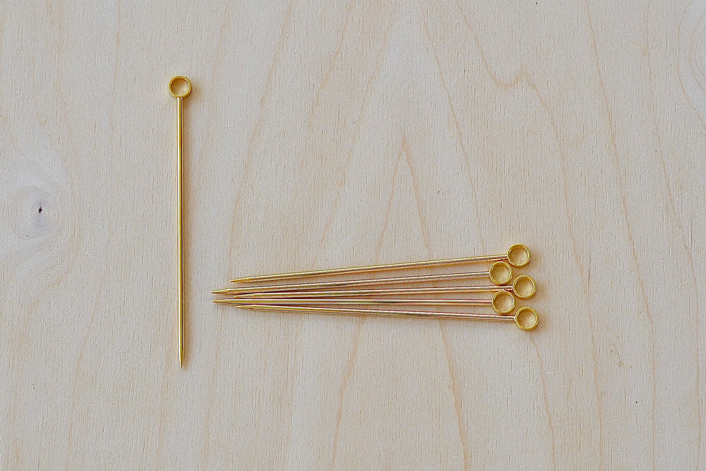 A set of six gold circle and gold plated cocktail picks made in Japan.