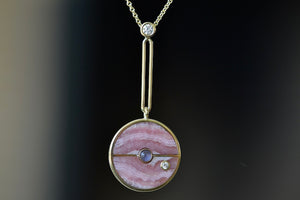 
            
                Load image into Gallery viewer, Close up of  The signature Compass Pendant with Rhodochrosite and Tanzanite by Retrouvai is a pendant necklace with stone inlay that is accented with a center gem stone and a white diamond.
            
        