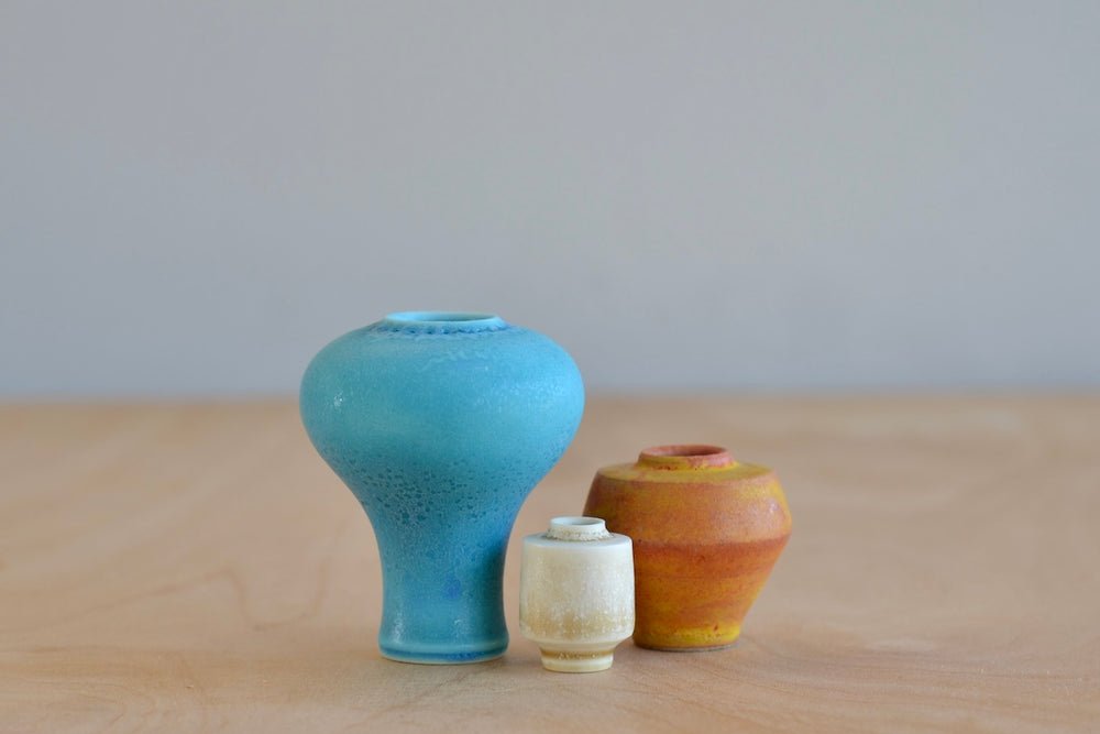 Miniature Hand Thrown Ceramic Vase Trio in turquoise, orange and cream  aginst white by Yuta Segawa.