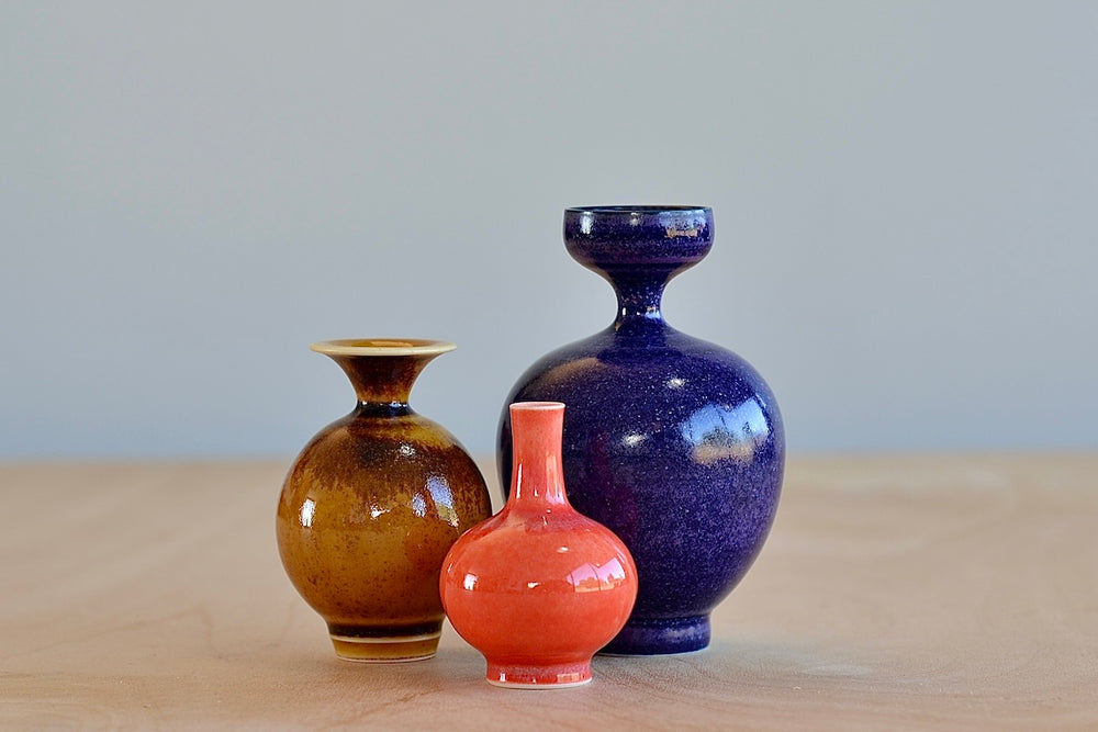 Miniature Hand Thrown Ceramic Vase Trio "G" in Coral, Violet and Brown on white background by Yuta Segawa.