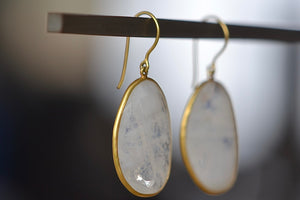 
            
                Load image into Gallery viewer, Side view of Large Drop Rainbow Moonstone Earrings by Pippa Small are translucent, lightly faceted and bezel set stones on ear wire in 18k yellow gold.
            
        