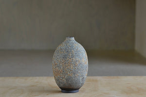 Other side of short hand thrown stoneware vase with volcanic glaze in green and orange by Heather Rosenman. 