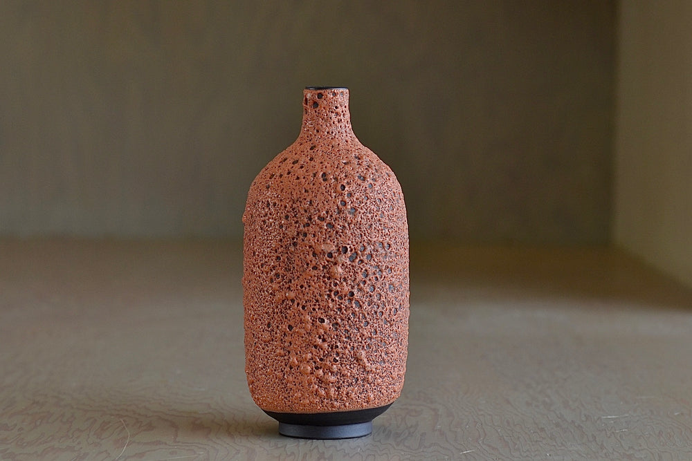 Alternate view of Heather Rosenman orange ceramic bottle vase in volcanic glaze.