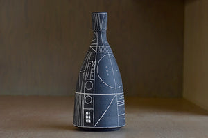 
            
                Load image into Gallery viewer, Alternate side of Heather Rosenman &amp;quot;Scribe&amp;quot; vase in brown with white sgraffito patterns is a hand thrown stoneware vase by Heather Rosenman.
            
        