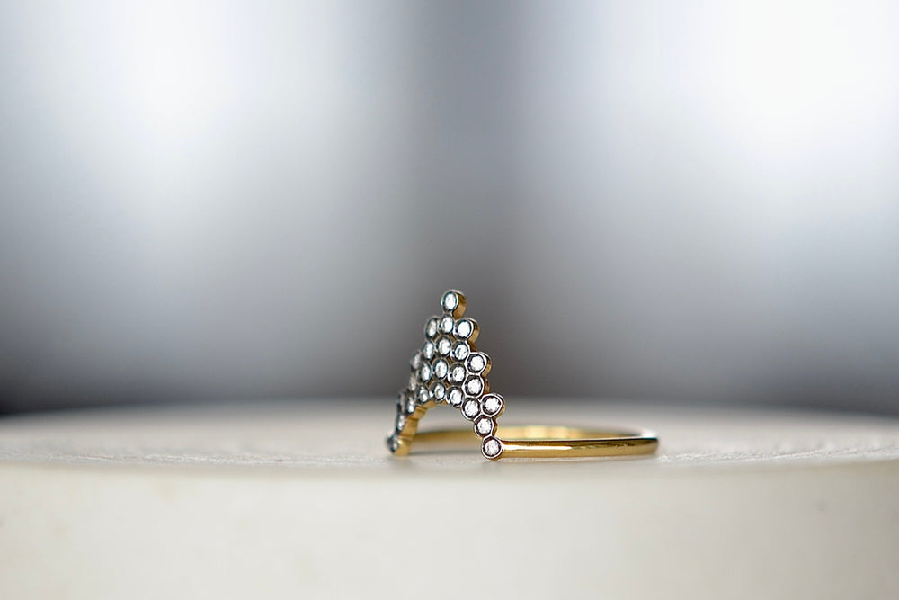 
            
                Load image into Gallery viewer, Side view of Pétale  Ring in size 6.5 by Yannis Sergakis is a triangular formation of twenty-five bezel set and rhodium plated round cut diamonds on a gold band in 18k gold. Minimalist and designed to be worn every day.
            
        