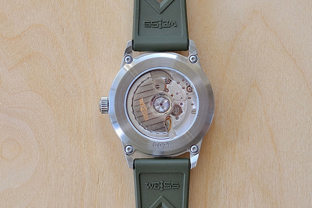 
            
                Load image into Gallery viewer, Back of Weiss Watch 38mm Automatic Field Watch with White Dial and date, shown with olive rubber strap , made with American parts. 
            
        